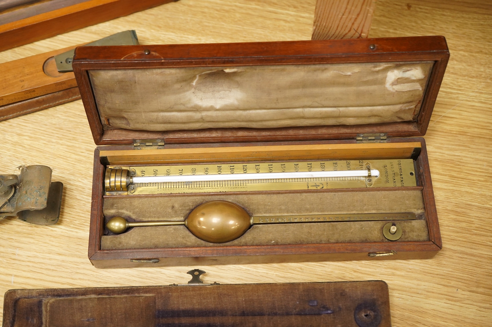 Five scientific instruments, comprising; a rolling parallel rule, pine boxed, 48cm wide; an early 20th century boxwood and brass Alidade, by J. Hicks, 8, 9 & 10, Hatton Garden, leather cased; an oak and brass tripod, sta